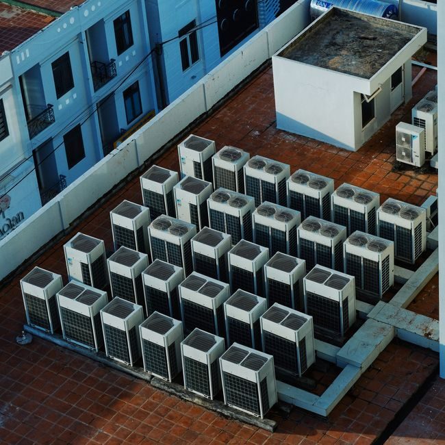Rooftop array of commercial HVAC condenser units on a Miami building